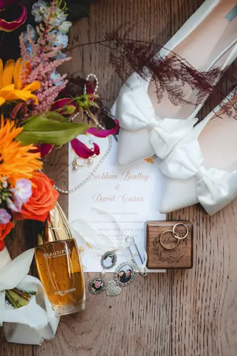 Bridal details at Millbrook Lodge with wedding rings, shoes, perfume and bouquet in soft spring light