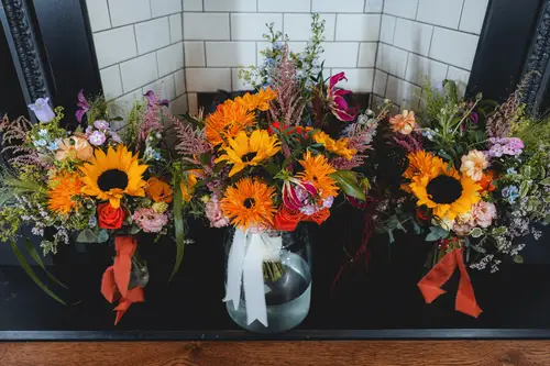 Sunflower wedding flowers and rustic floral decor in soft light at Millbrook Lodge, Ballynahinch