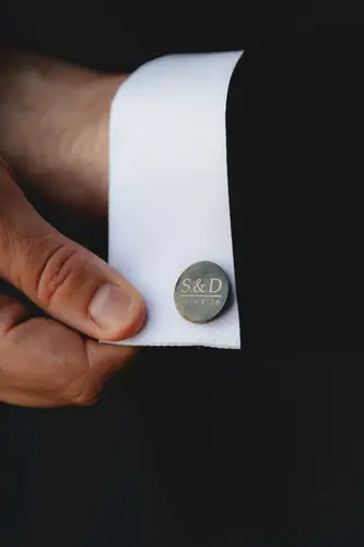 Groom fastening cufflinks during wedding morning preparations at Millbrook Lodge, Ballynahinch