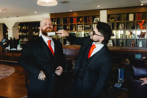 Groom and groomsmen share a laugh in the Millbrook Lodge bar lounge during wedding morning preparations