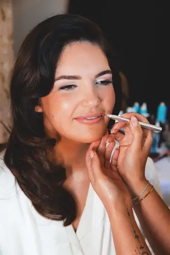 Bride having her makeup finished in soft morning light at Millbrook Lodge, Ballynahinch