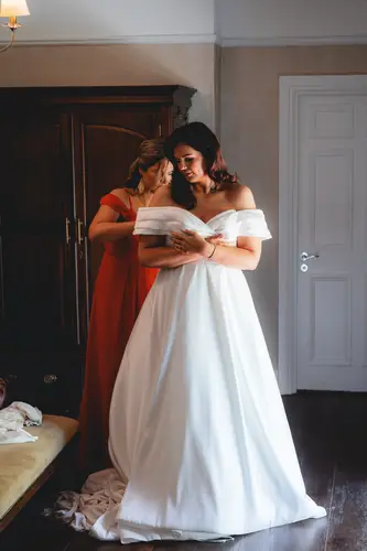 Bride having her wedding dress fastened during bridal prep at Millbrook Lodge, Ballynahinch