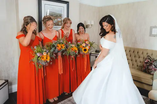 Bride and bridesmaids share a joyful dress reveal in natural light at Millbrook Lodge, Ballynahinch