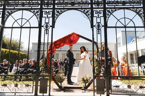 Bride and groom sharing vows at an outdoor Millbrook Lodge ceremony in sunny Ballynahinch