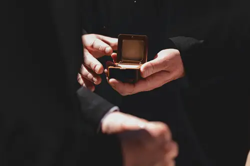 Groom holding the wedding rings in a ring box during the sunny ceremony at Millbrook Lodge, Ballynahinch