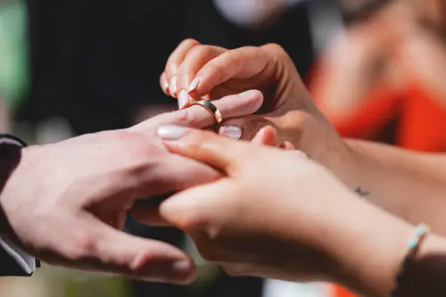 Close-up of the couple exchanging wedding rings during their outdoor ceremony at Millbrook Lodge in Ballynahinch