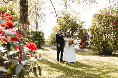 Bride and groom walking through the spring gardens at Millbrook Lodge, Ballynahinch