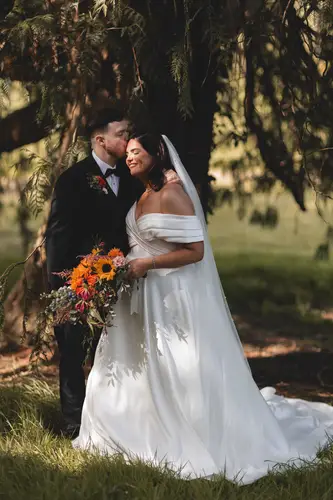 Bride and groom in golden woodland light during portraits at Millbrook Lodge, Ballynahinch