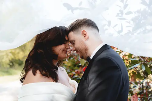 Bride and groom sharing a quiet forehead touch in soft daylight at Millbrook Lodge, Ballynahinch