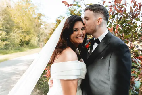 Bride and groom sharing a forehead kiss outdoors at Millbrook Lodge, Ballynahinch
