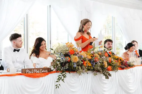 Laughter at the top table during wedding speeches at Millbrook Lodge in Ballynahinch
