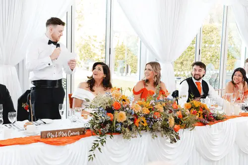 Groom giving his speech at the top table during a bright marquee reception at Millbrook Lodge