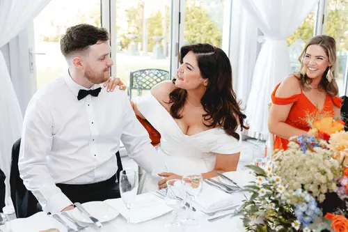 Bride and groom laughing at the top table during speeches at Millbrook Lodge, Ballynahinch