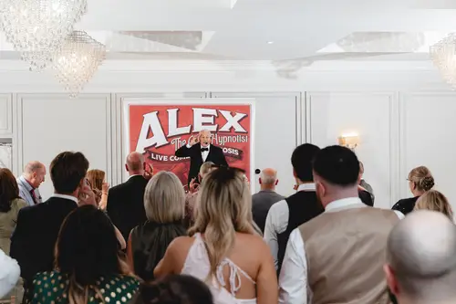 Wedding guests laughing during live entertainment at the Millbrook Lodge reception in Ballynahinch