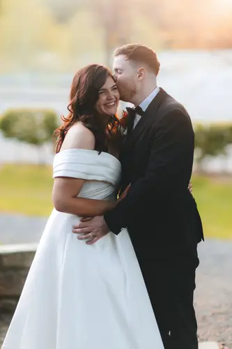 Bride and groom laughing during a golden hour portrait at Millbrook Lodge in Ballynahinch