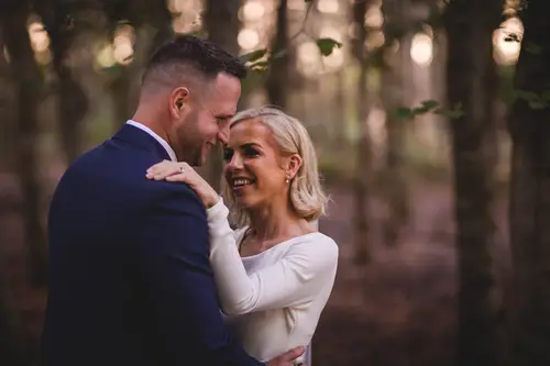 Bride and groom embracing in soft woodland light during couple portraits at Old Rectory, Killyman