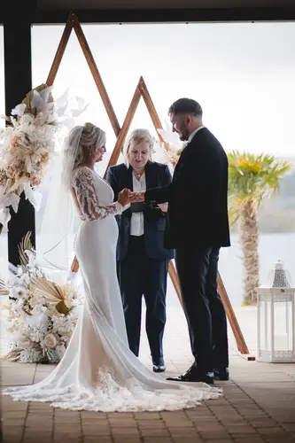 Bride and groom exchanging vows beneath a floral arch during their ceremony at Rossharbour Resort, Lough Erne