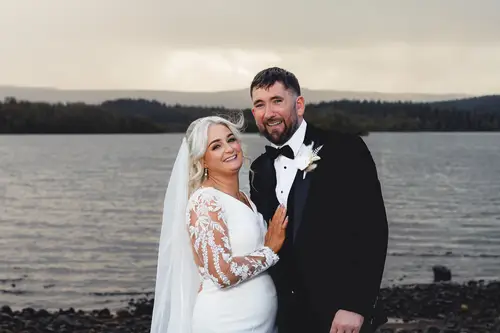 Bride and groom in a quiet lakeside portrait at Rossharbour Resort, Lough Erne, with soft overcast light and a flowing veil