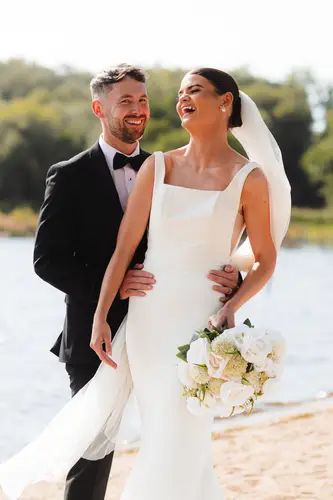 Bride and groom laughing during lakeside couple portraits at Rossharbour Resort, Lough Erne