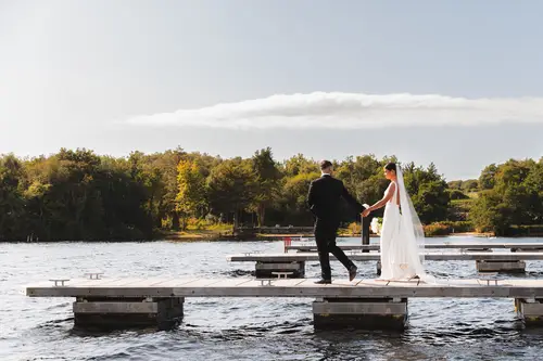 Bride and groom walking on the lakeside jetty at Rossharbour Resort, Lough Erne, during sunny couple portraits