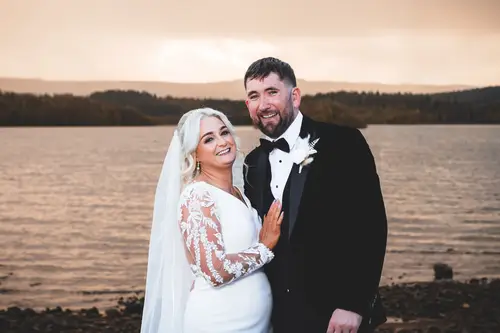 Bride and groom by the water at Rossharbour Resort, Lough Erne, in soft sunset light