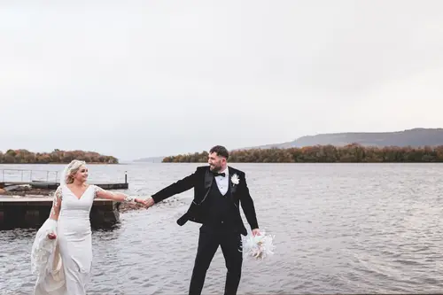 Bride and groom holding hands on the dock at Rossharbour Resort, Lough Erne, in soft overcast light