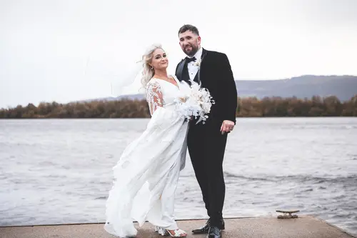 Bride and groom portraits by the lakeside at Rossharbour Resort, with a windy veil and soft overcast light
