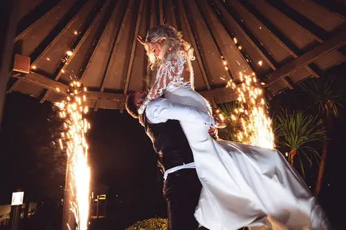 Bride and groom in a joyful night portrait with sparklers at Rossharbour Resort, Lough Erne
