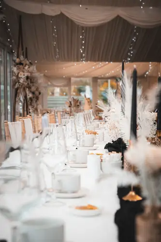 Reception tables with white decor, floral centrepieces and fairy lights at Rossharbour Resort, Lough Erne