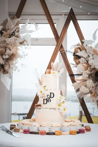 Wedding cake and macaron dessert table with floral decor at Rossharbour Resort, Lough Erne