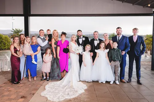 Family and bridal party group portrait on the covered terrace at Rossharbour Resort, Lough Erne, with children and natural light