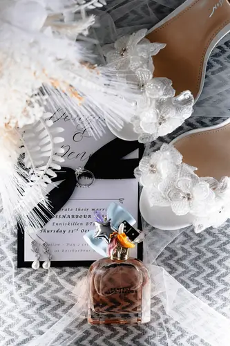 Bridal details flat lay with wedding shoes, perfume and invitation in soft morning light at Rossharbour Resort