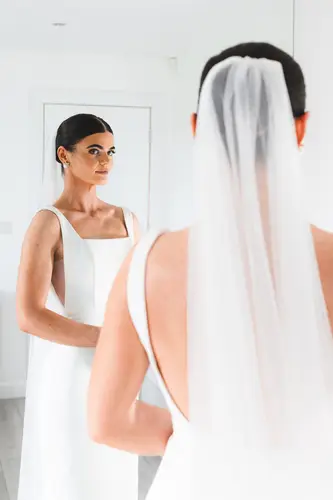 Bride in veil and wedding dress reflected in a mirror during calm morning prep at Rossharbour Resort, County Fermanagh