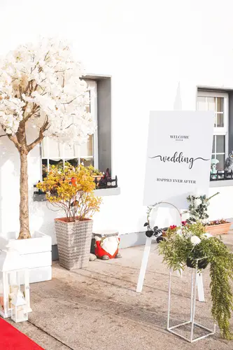 Welcome sign with floral decor at the entrance to Rossharbour Resort in Lough Erne on a bright wedding morning