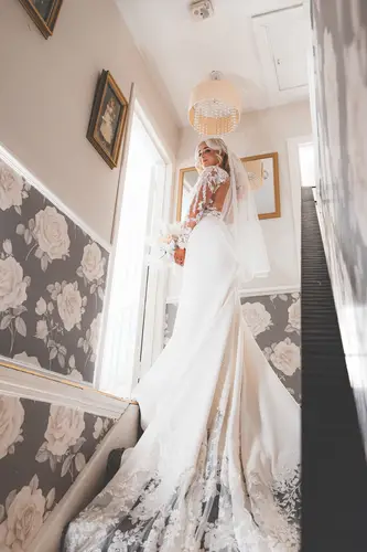 Bride in veil and wedding dress on the staircase at Rossharbour Resort, softly lit during morning preparations
