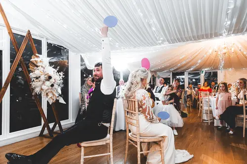 Bride and groom laughing during a reception party game in the marquee at Rossharbour Resort, Lough Erne