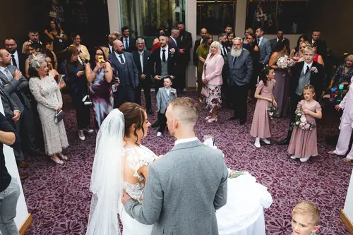 Bride and groom during an emotional indoor ceremony at Stormont in Belfast, with guests watching in natural light