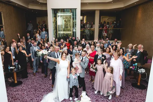 Guests wave around the bride and groom during an indoor wedding celebration at Stormont, Belfast.