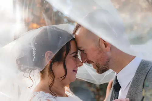 Close-up couple portrait at Stormont in Belfast with the bride’s veil softly framing a quiet moment