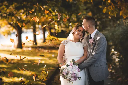 Bride and groom in warm golden-hour light during autumn couple portraits at Stormont in Belfast