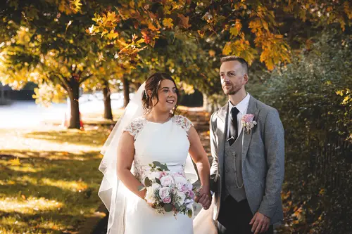 Bride and groom in golden autumn light during couple portraits at Stormont, Belfast