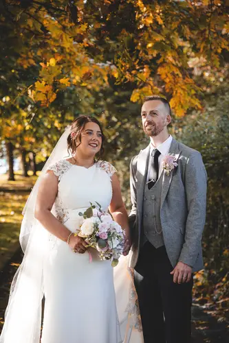 Newlyweds in golden autumn light during outdoor couple portraits at Stormont, Belfast