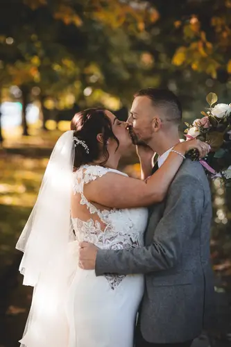 Bride and groom share a quiet kiss during golden hour portraits at Stormont in Belfast