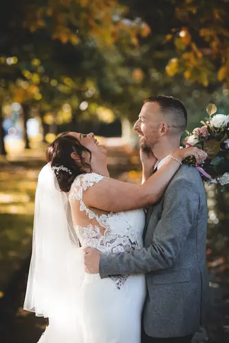Laughing bride and groom during golden hour portraits at Stormont in Belfast, with autumn trees and soft natural light.