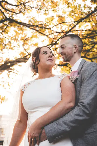 Backlit couple portrait at Stormont in Belfast with autumn trees and warm golden hour light