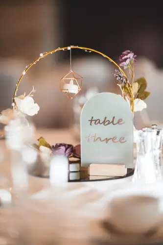 Candlelit wedding table decor with floral accents and table number at Stormont in Belfast