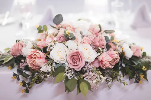 Pink rose floral centrepiece on a softly lit reception table at a Stormont wedding in Belfast