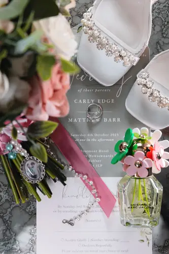 Bridal shoes, bouquet, invitation and jewellery laid out in soft light for a Stormont wedding in Belfast