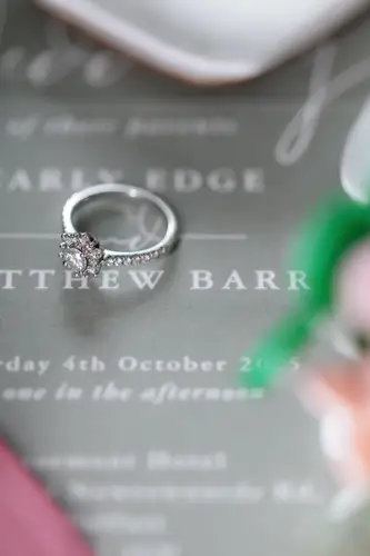 Wedding rings and stationery flatlay in soft light at Stormont in Belfast
