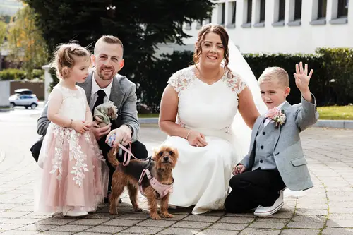 Bride with children and a dog during relaxed outdoor family portraits at Stormont in Belfast